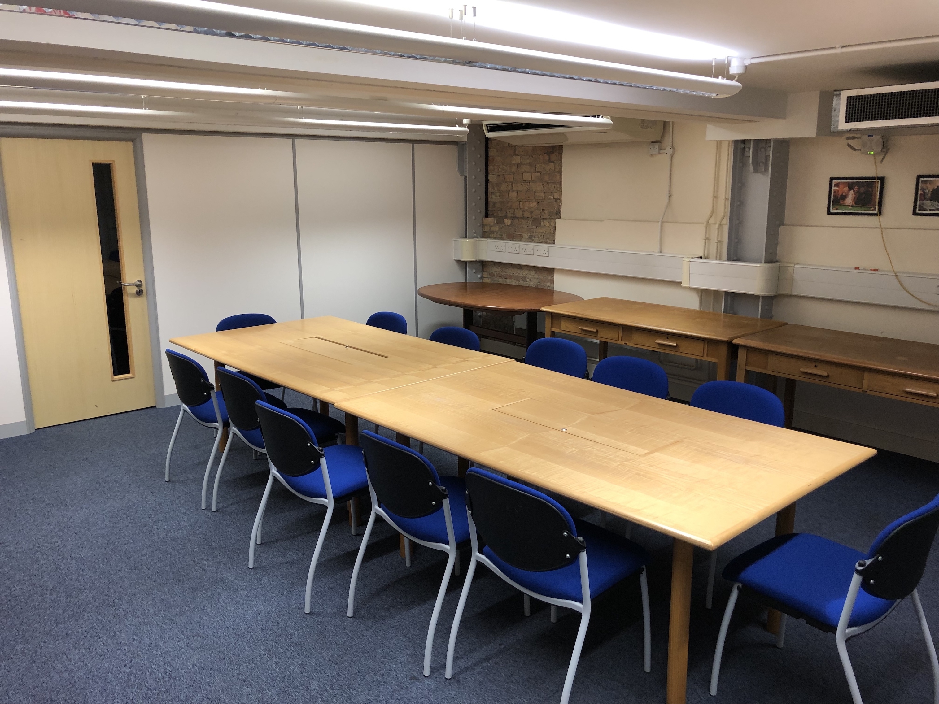 Photograph showing the standard layout of the Mill Lane Committee Room - a room with twelve chairs around a large boardroom table.