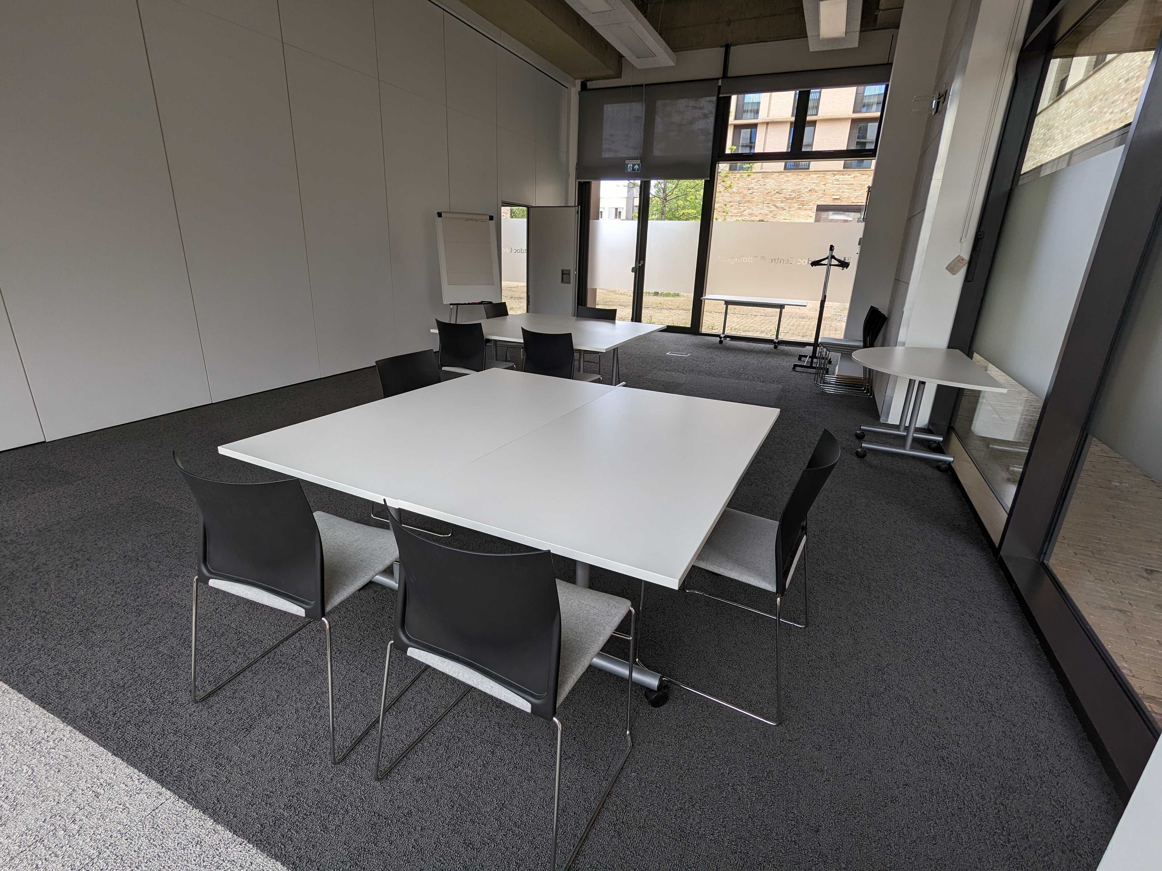 Photograph showing the workshop-style layout of the Multi-Function Space - a room with eight chairs arranged around two tables.