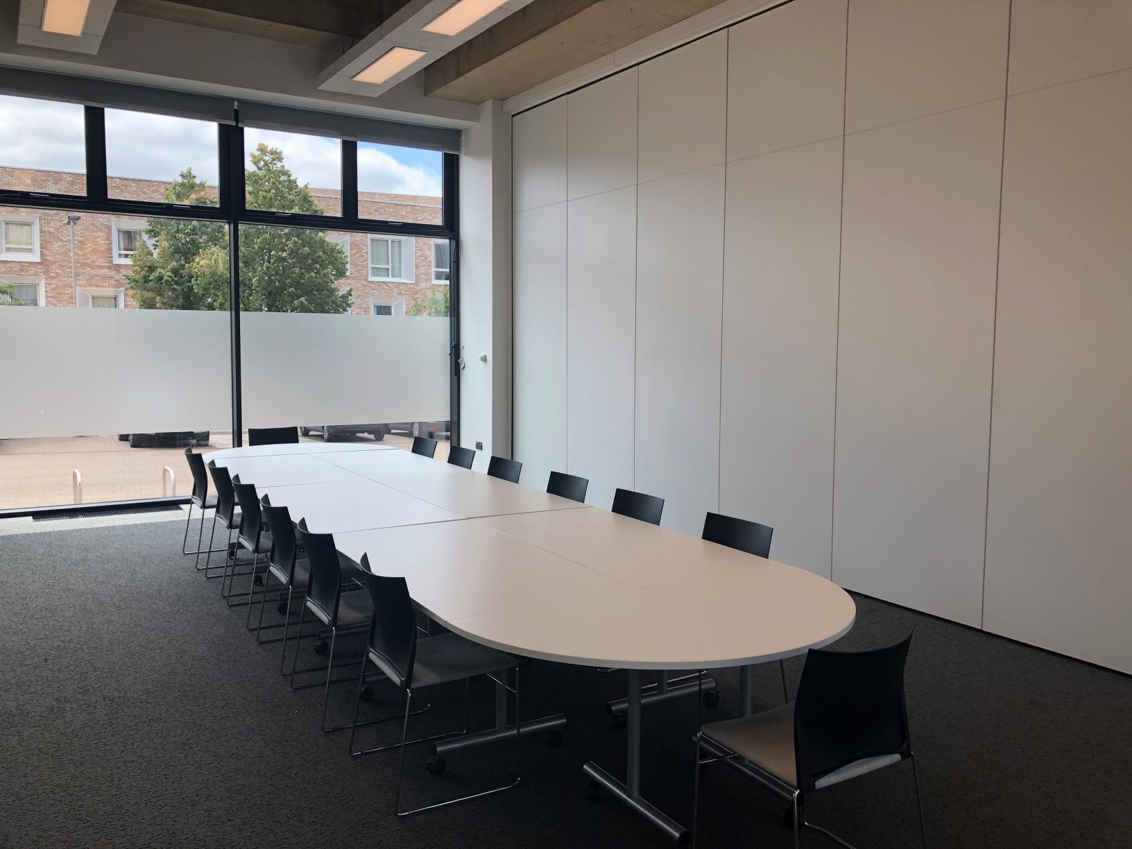 Photograph showing the boardroom-style layout of the Multi-Function Space - a room with fourteen chairs around a large boardroom table.