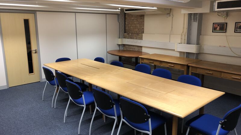 Photograph showing the standard layout of the Mill Lane Committee Room - a room with twelve chairs around a large boardroom table.