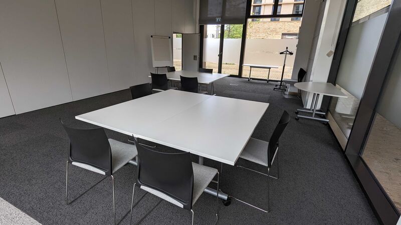 Photograph showing the workshop-style layout of the Multi-Function Space - a room with eight chairs arranged around two tables.
