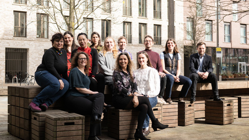 The Postdoc Academy team sitting on a bench outside the Eddington Postdoc Centre.